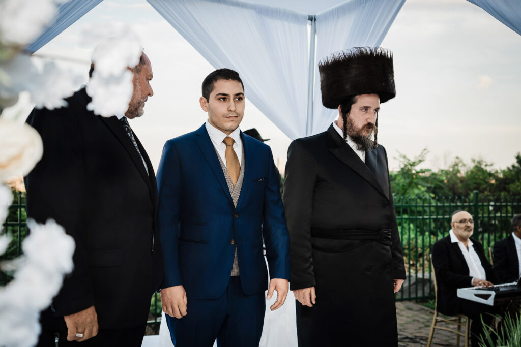 Groom waiting at chuppah with NYC skyline backdrop at Riverview Ballroom Orthodox Jewish wedding New Jersey