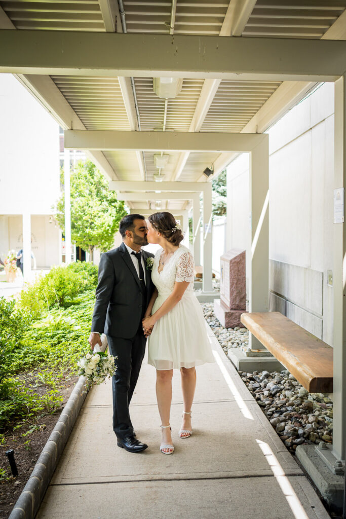 Newlyweds walking together in Bergen County courthouse covered walkway by Alex Kaplan