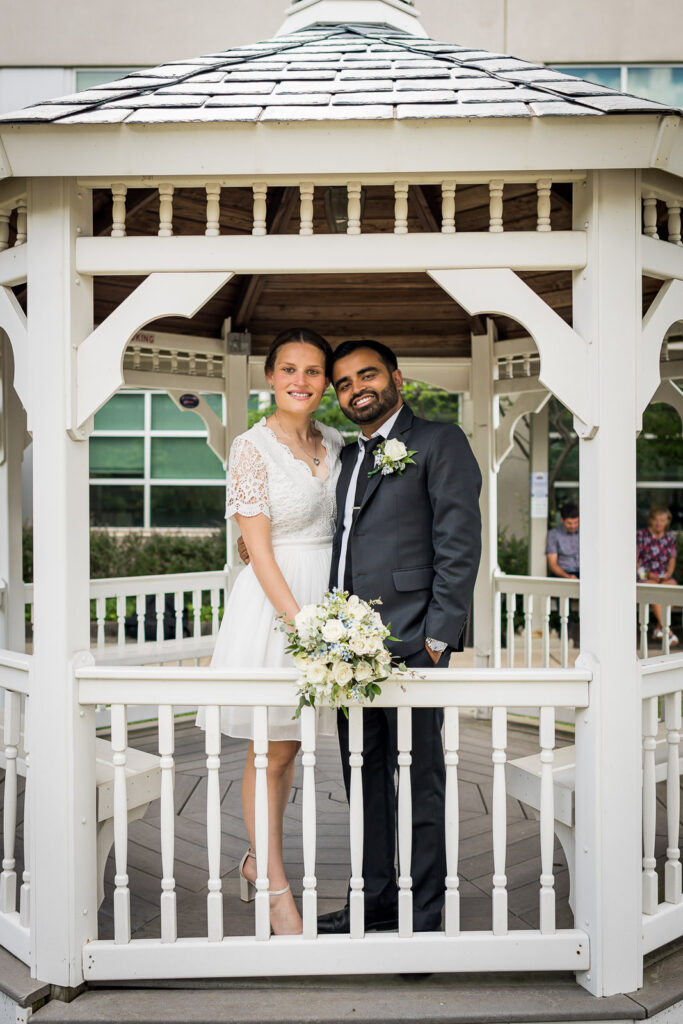 Couple framed in Bergen County Plaza gazebo architecture by Alex Kaplan wedding photographer