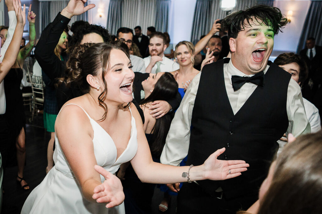 Bride and groom dancing together surrounded by guests at Mansion at Mountain Lakes