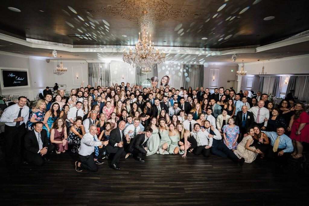 All 200 wedding guests gathered for group photo in Mansion at Mountain Lakes ballroom