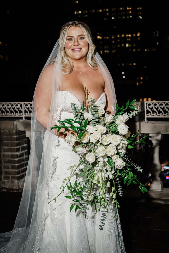 Bridal portrait with cascading white bouquet on Midtown Loft rooftop NYC