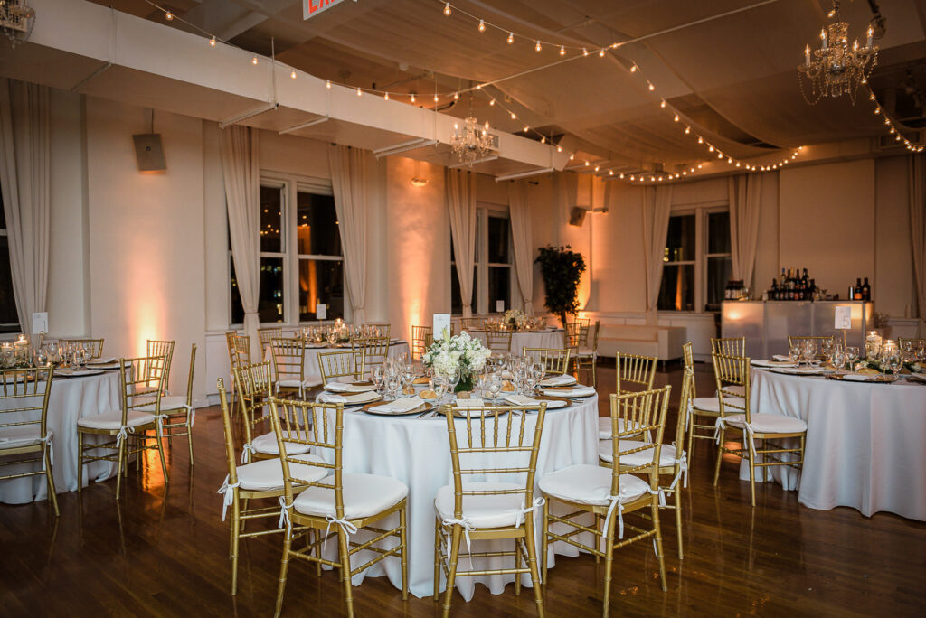 Reception decor with gold chiavari chairs and string lights at Midtown Loft