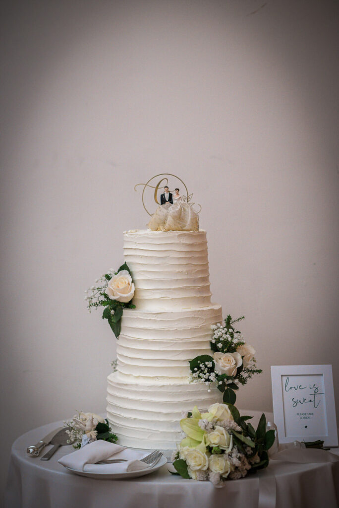 Three-tier white wedding cake with roses at Midtown Loft & Terrace