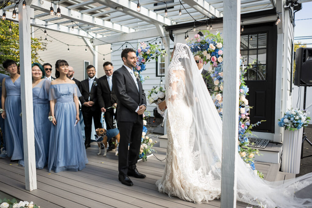 Couple with dog and bridal party during NJ home wedding ceremony