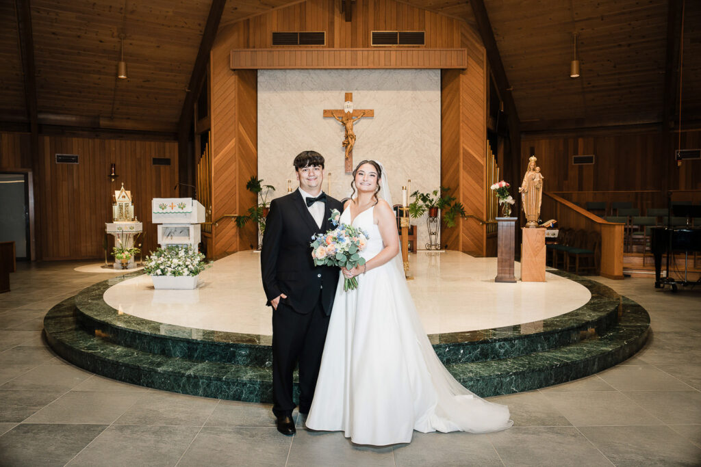 Bride and groom formal portrait at altar of Notre Dame of Mt Carmel Church
