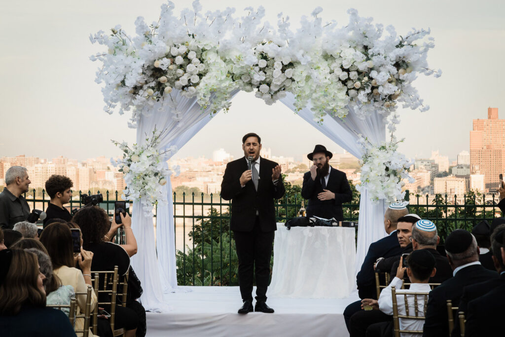 Rabbi officiant at outdoor rooftop ceremony with Manhattan skyline at Riverview Ballroom wedding Cliffside Park