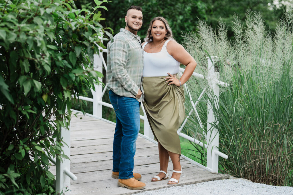 Couple standing on white wooden bridge at Sayen House and Gardens Hamilton Square NJ engagement photos