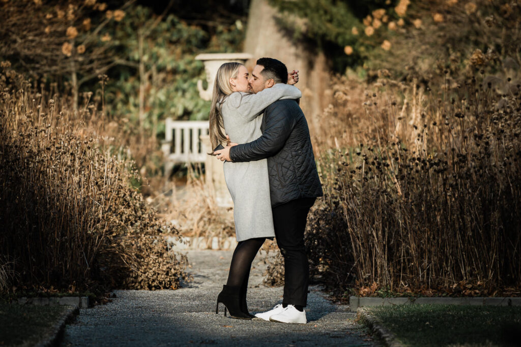 Newly engaged couple kissing after proposal at Van Vleck House and Gardens in Montclair New Jersey