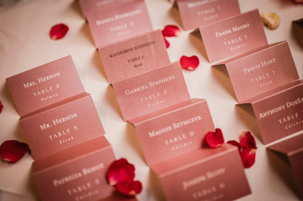 Rose gold wedding escort cards with rose petals by Alex Kaplan Photography