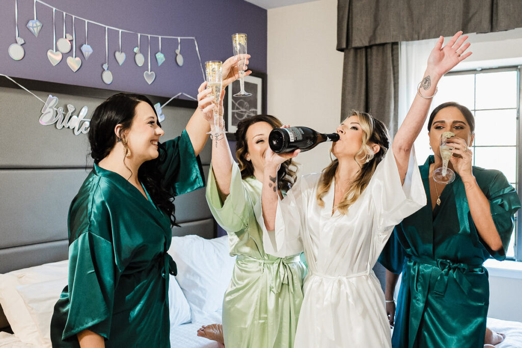 Bride and bridesmaids getting ready with champagne toast - wedding day timeline