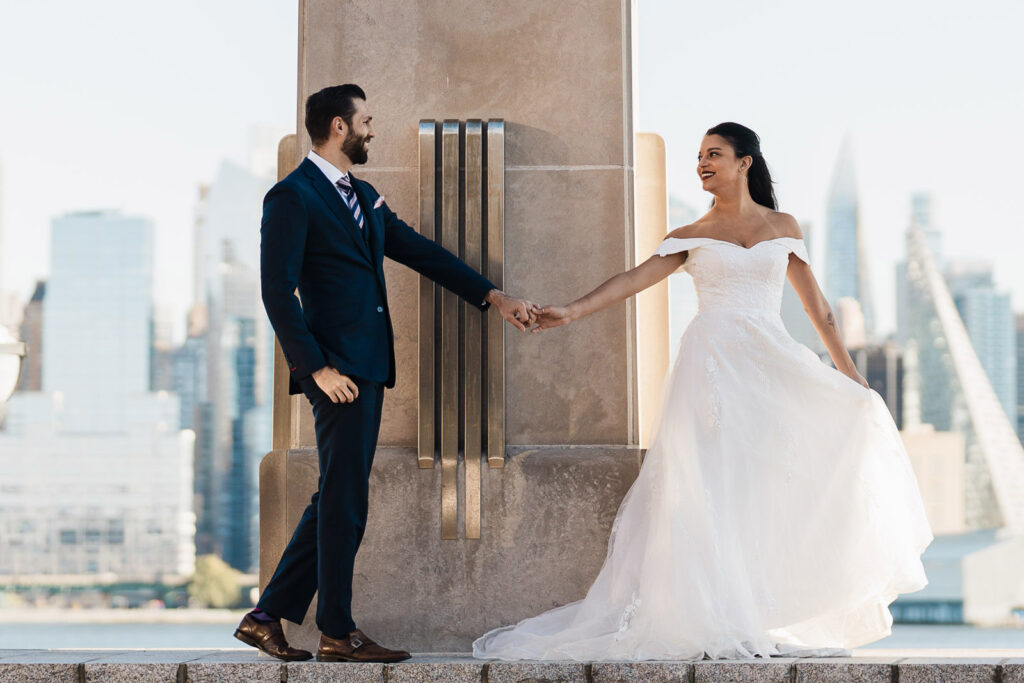 Joanna and Alex with modern architecture and Manhattan skyline Port Imperial West New York elegant wedding photos