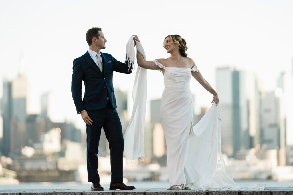 Luz and Stephan dancing with shawl and Manhattan skyline Port Imperial West New York joyful wedding moment