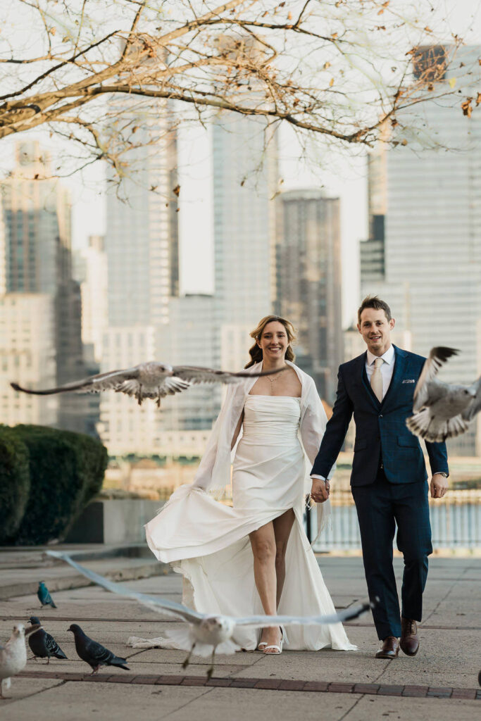 Seagull flying as Luz and Stephan walk together with Manhattan skyline Port Imperial spontaneous wedding moment