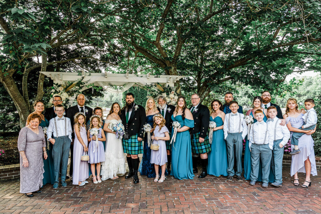 Large extended family portrait including grandmothers children and full wedding party at Smithville Inn Scottish wedding in New Jersey