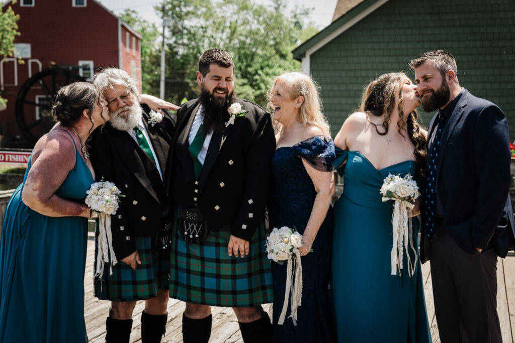 Scottish wedding groomsmen in traditional kilts with bridesmaids in teal dresses at Smithville Inn New Jersey by Alex Kaplan Photography
