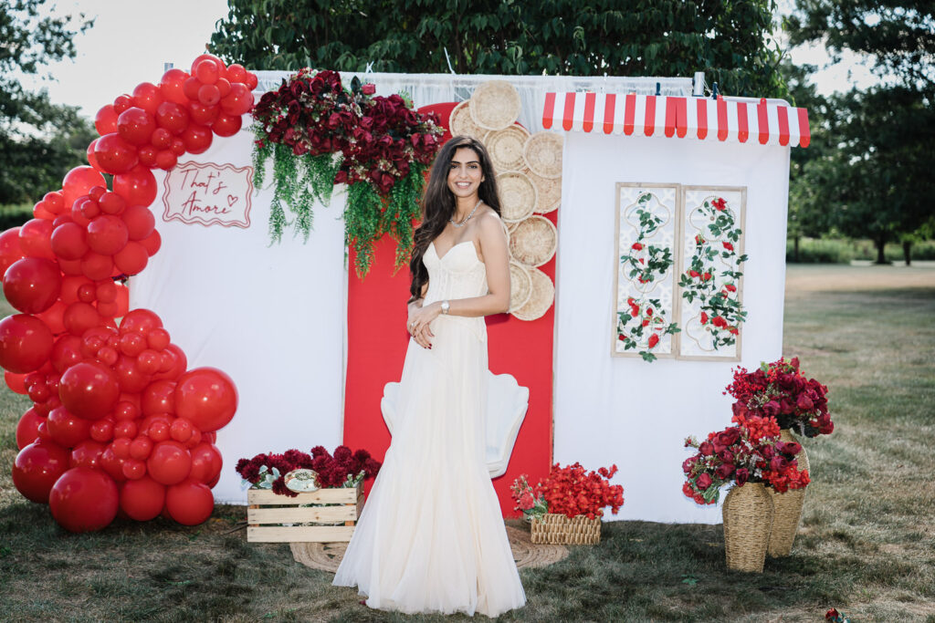 Bride standing at That's Amore backdrop with red and white decor