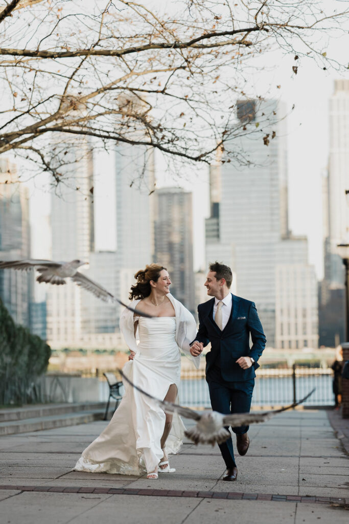 Candid fun couple portraits at Brooklyn Bridge Park with NYC skyline