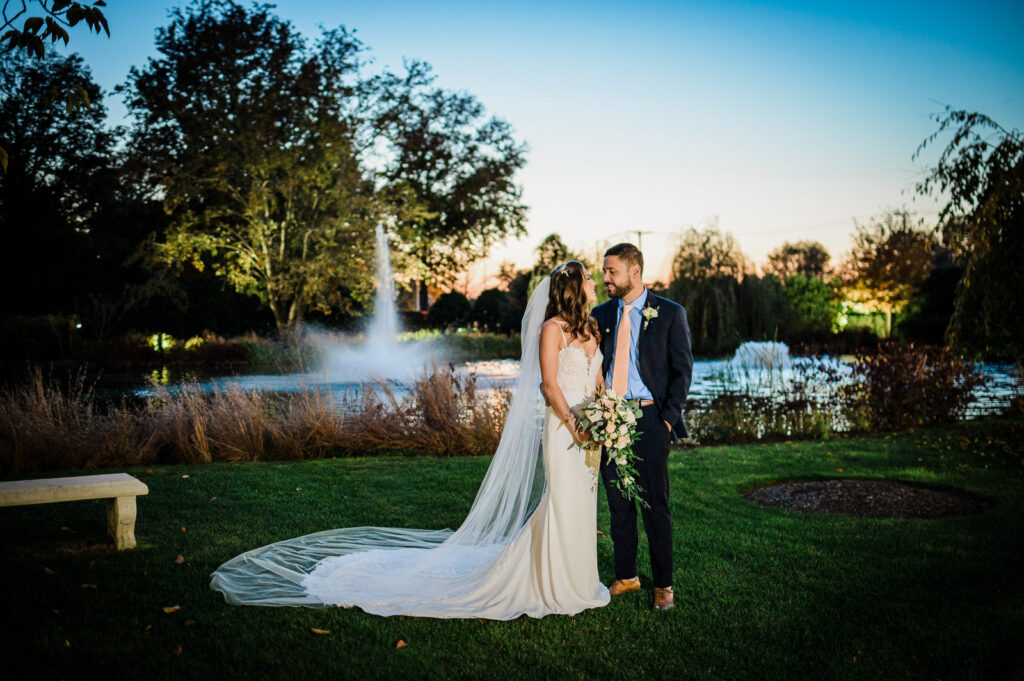 Bride and groom sunset portrait by fountain at Park Chateau Estate Gardens East Brunswick