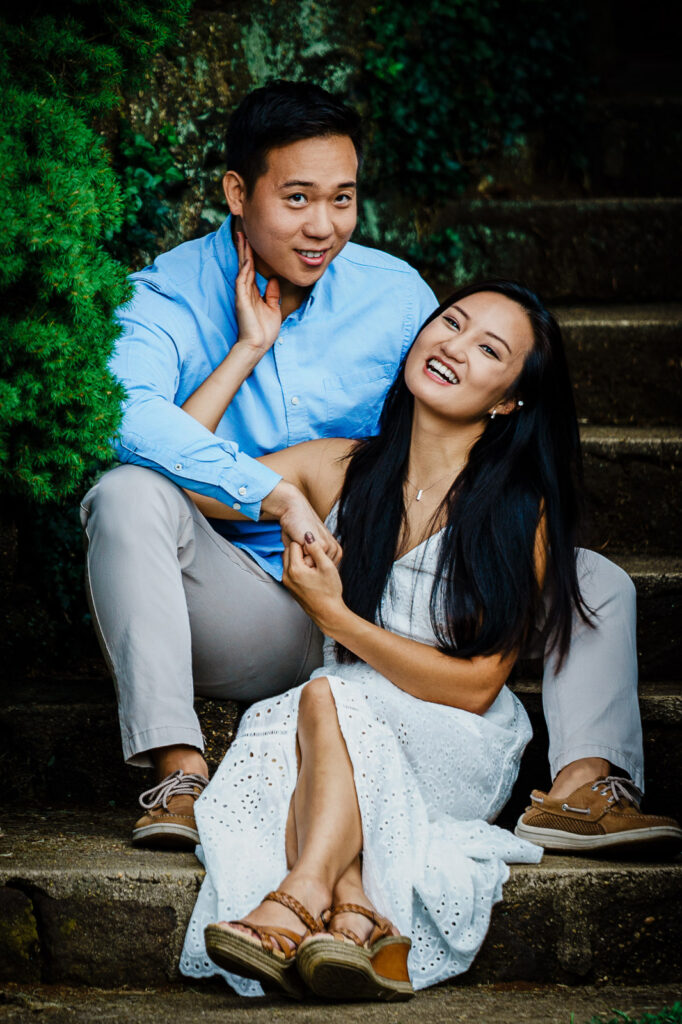 Relaxed engagement pose on stone architecture at Deep Cut Gardens