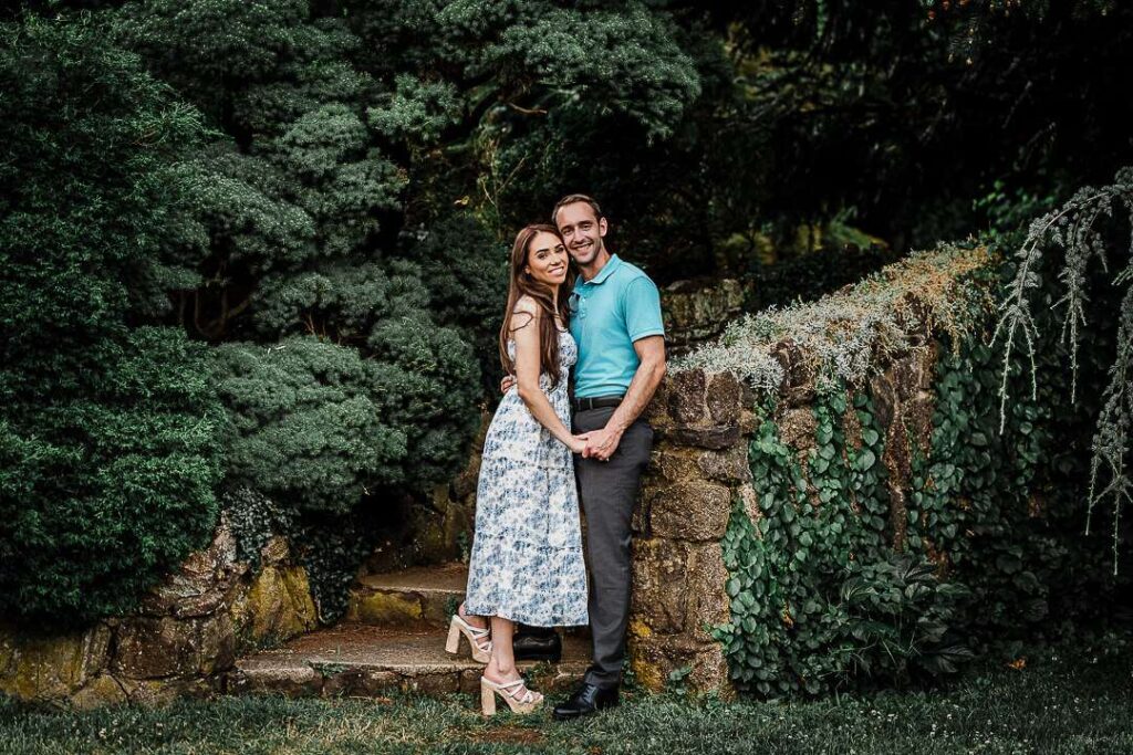 Engaged couple walking hand-in-hand through scenic garden path at Deep Cut Gardens Middletown NJ captured by Northern New Jersey proposal photographer Alex Kaplan
