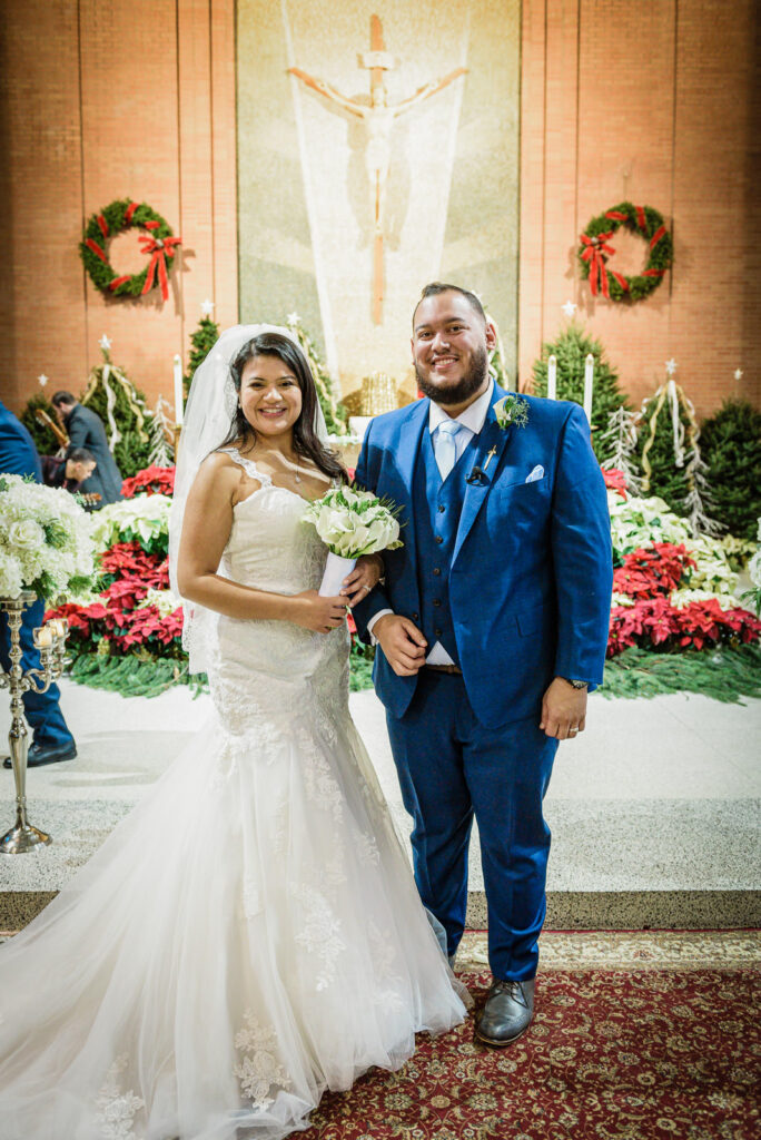 Formal portrait at St Theresa Church altar with Christmas poinsettias