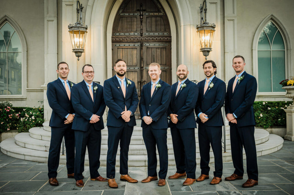 Groomsmen in navy suits with peach ties at Park Chateau chapel in East Brunswick NJ