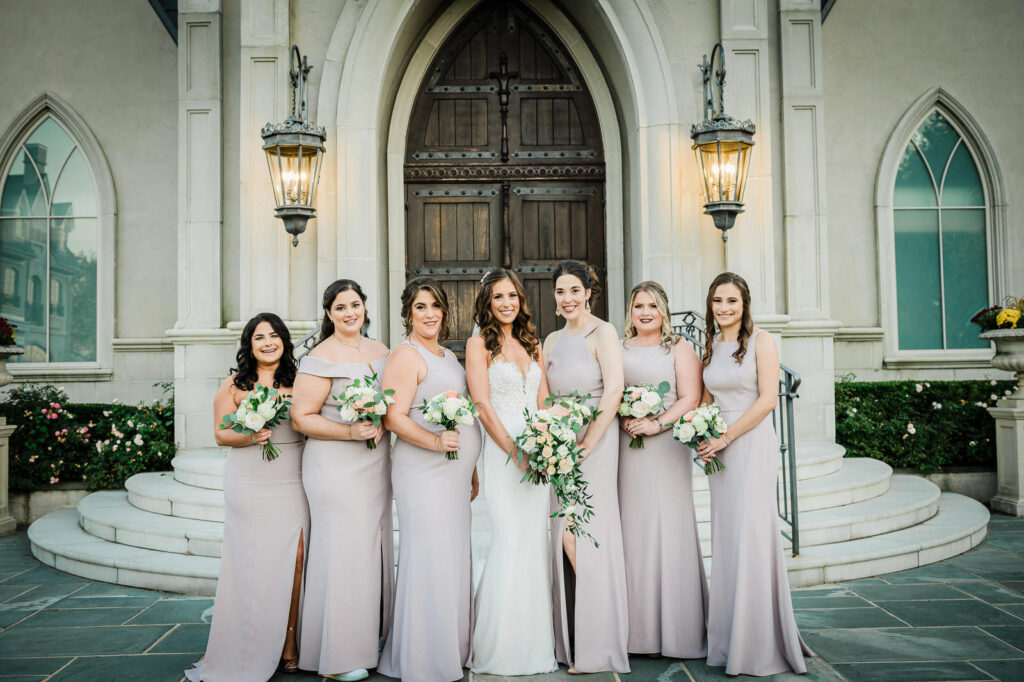 Wedding party celebrating with raised bouquets at Park Chateau chapel East Brunswick