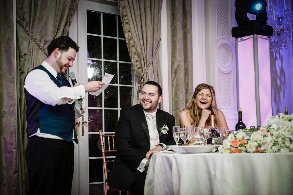 Couple laughing during reception speeches at Rockleigh Country Club