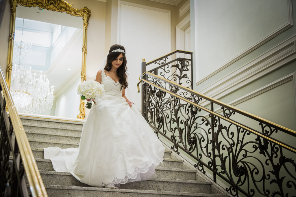 Bride in ball gown descending the grand staircase at Rockleigh Country Club in New Jersey