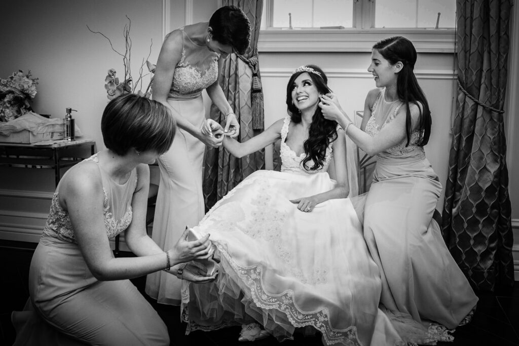 Bride getting ready with bridesmaids at Rockleigh Country Club surrounded by champagne colored dresses