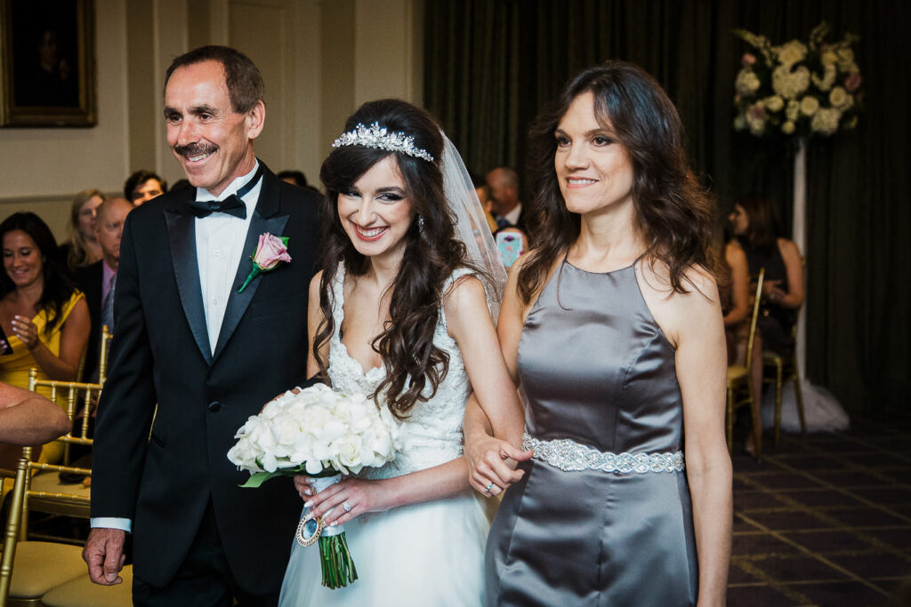 Bride walking down the aisle with parents at Rockleigh Country Club wedding ceremony