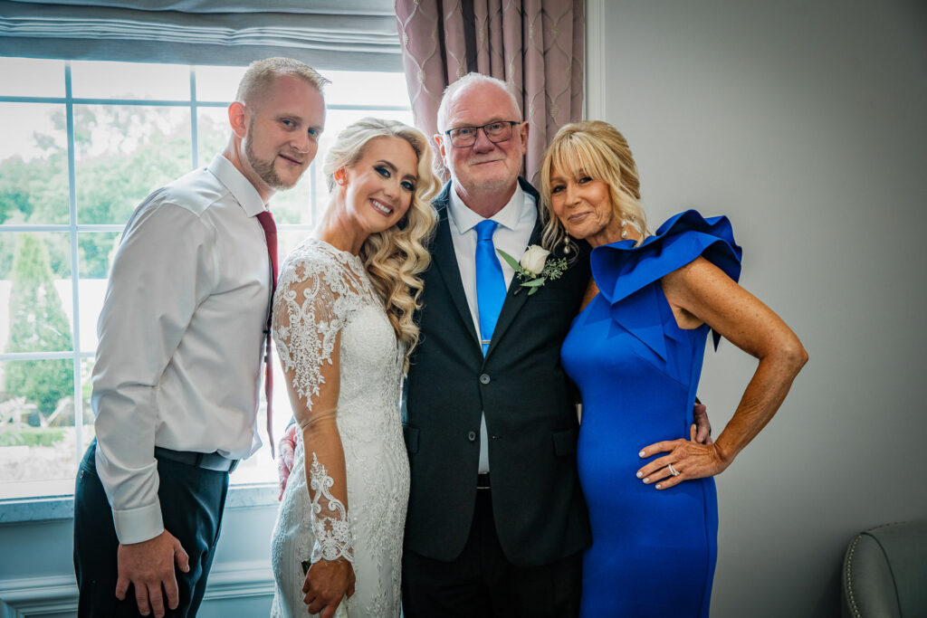 Groom in navy suit with parents including mother in traditional sari at Rockleigh Country Club