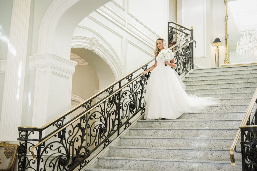 Bride on grand staircase Rockleigh Country Club elegant portrait