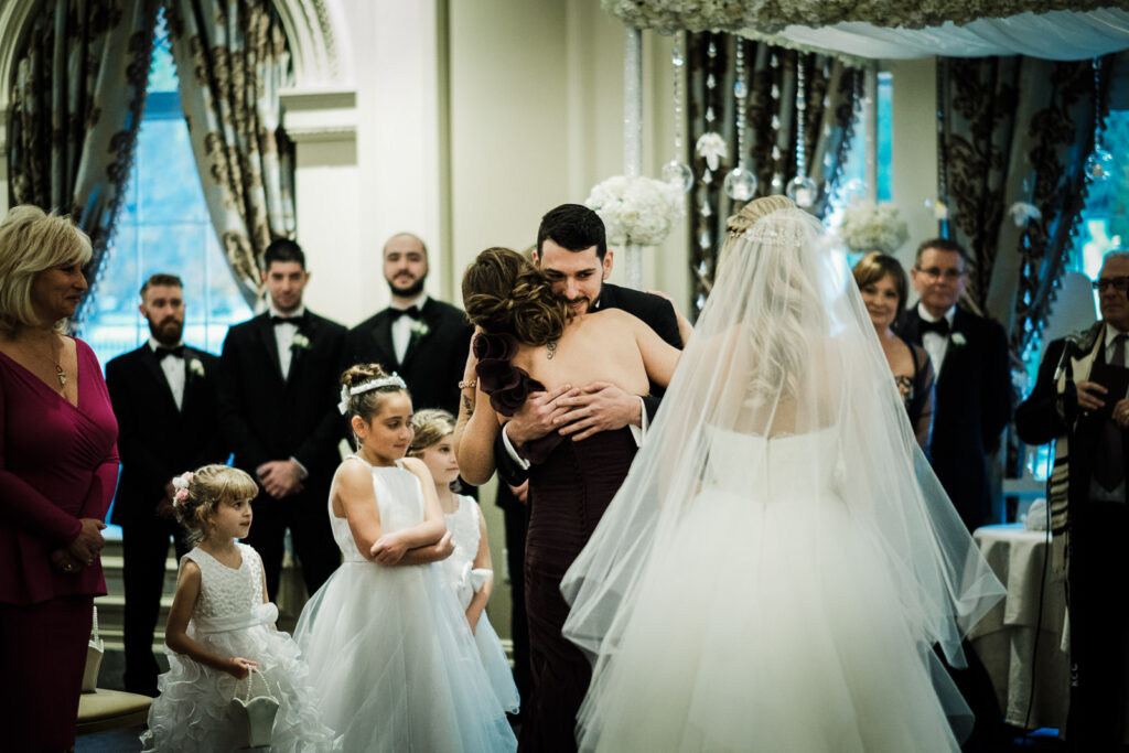 Groom hugging family member during ceremony Rockleigh Country Club