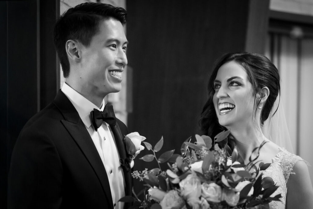 Black and white candid portrait of bride and groom laughing during Metropolitan Caterers Glen Cove reception