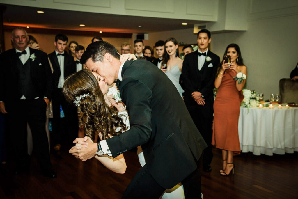 Groom dipping bride during first dance at Metropolitan Caterers wedding reception in Glen Cove NY