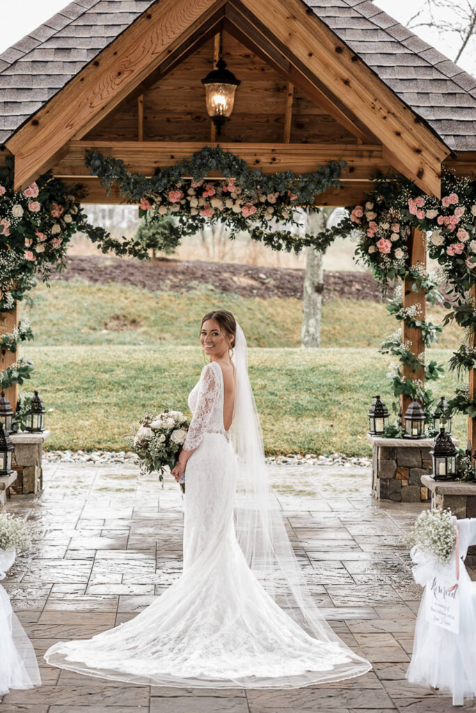 Bride in cathedral veil under ceremony pavilion at Hamilton Farm Golf Club