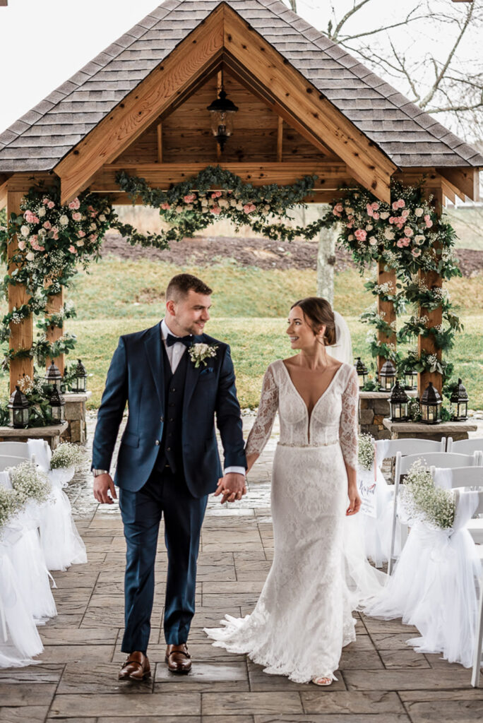 Newlyweds walking down aisle after ceremony at Hamilton Farm Golf Club