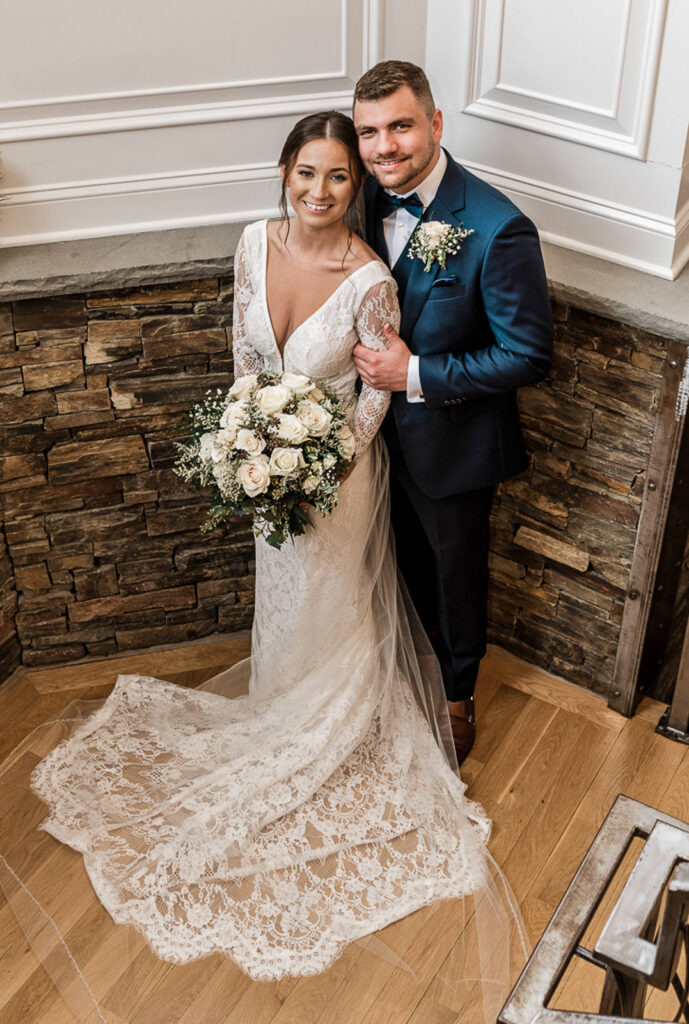 Bride and groom portrait against stone wall at Hamilton Farm Golf Club