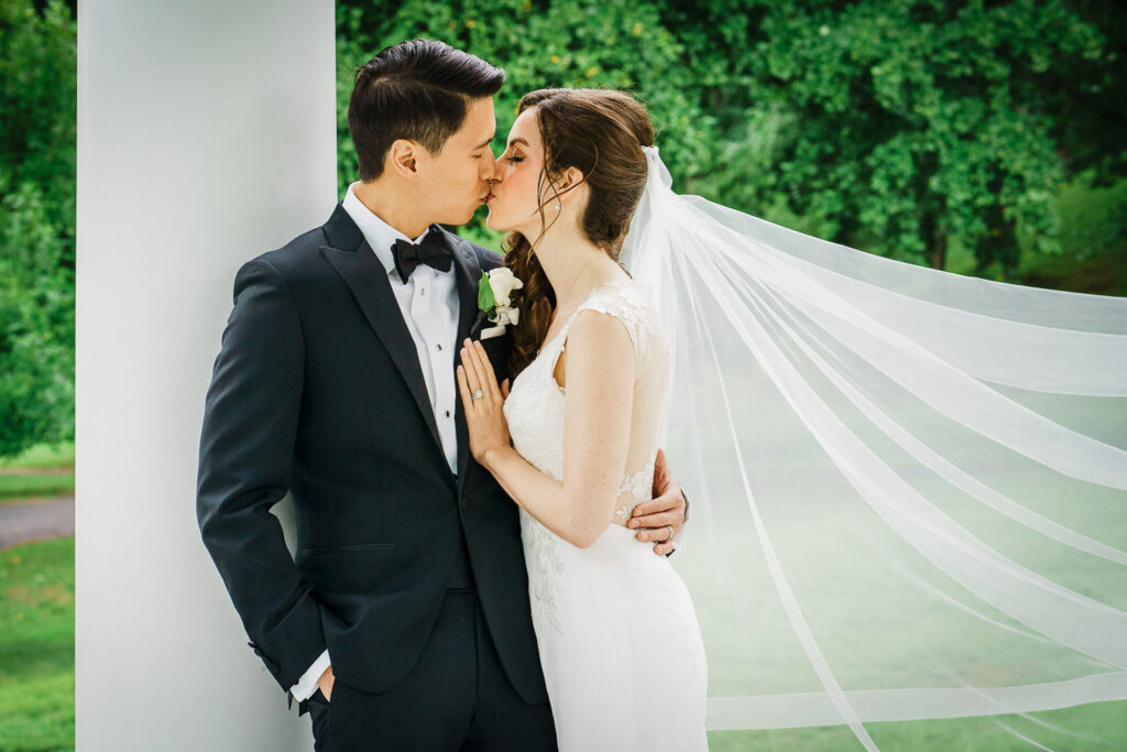 Intimate bride and groom portrait under flowing veil during rain at Glen Cove wedding