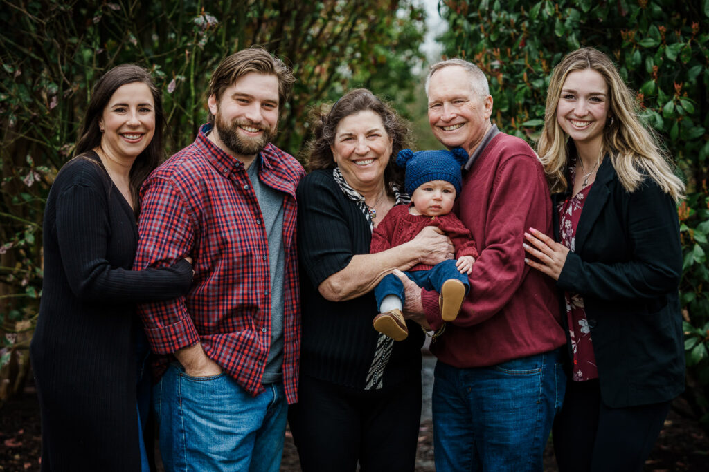 Extended family portrait of six adults with baby at Knight Park in Collingswood
