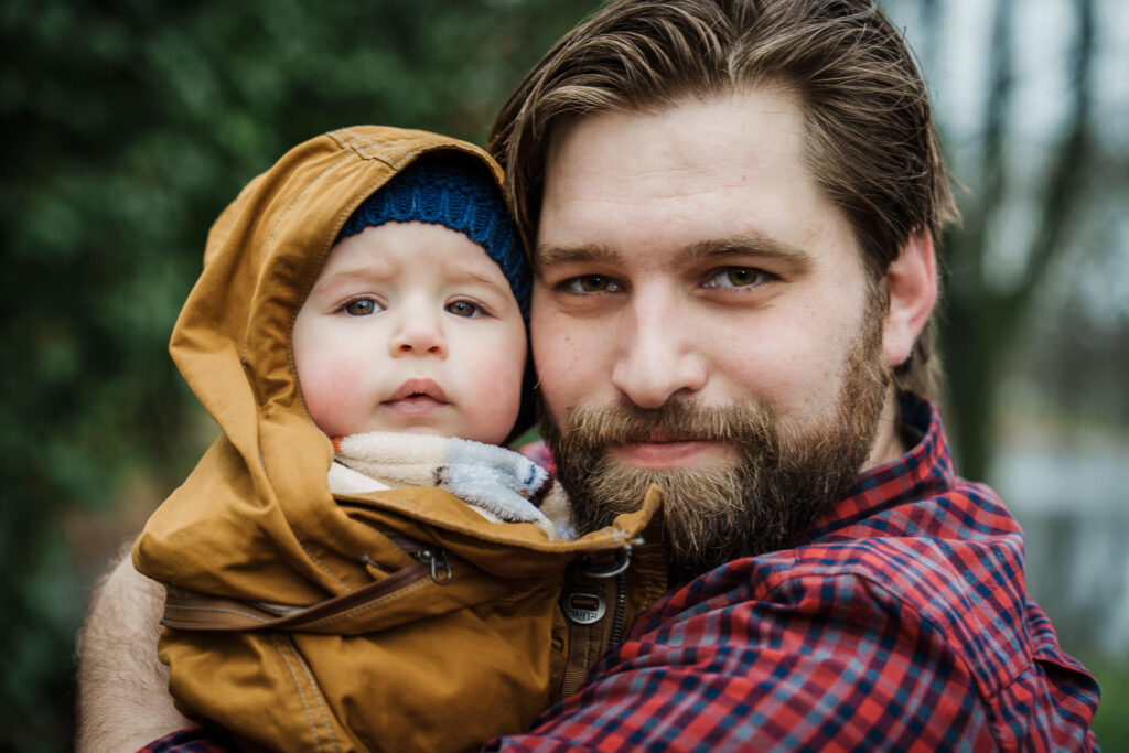 Father holding baby son outdoors at Knight Park in Collingswood
