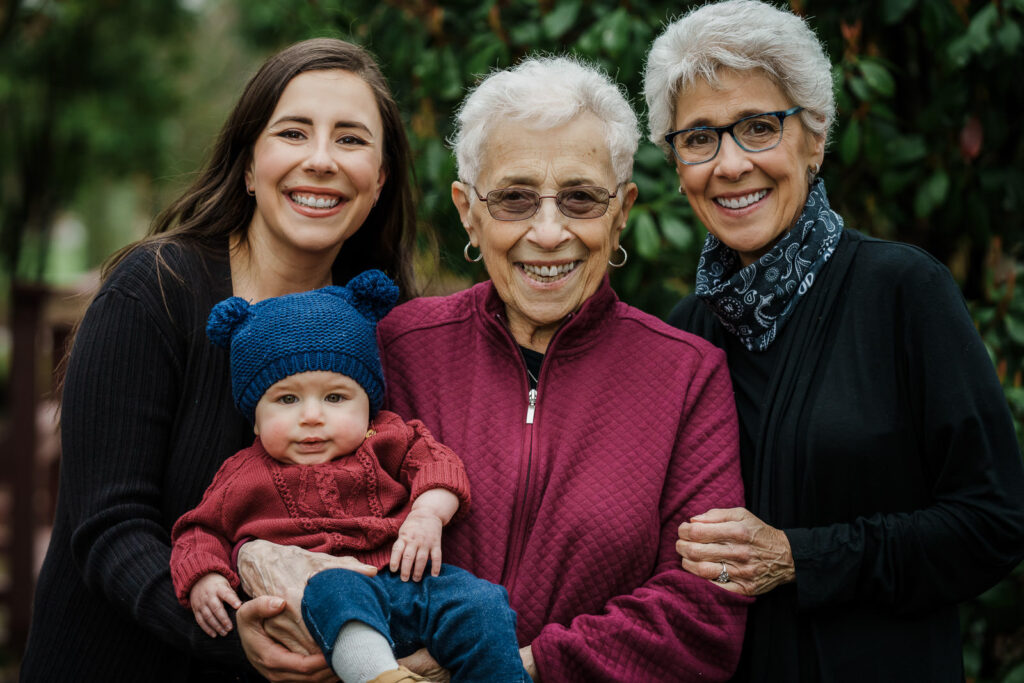 Four generations holding a baby during a family session at Knight Park in Collingswood