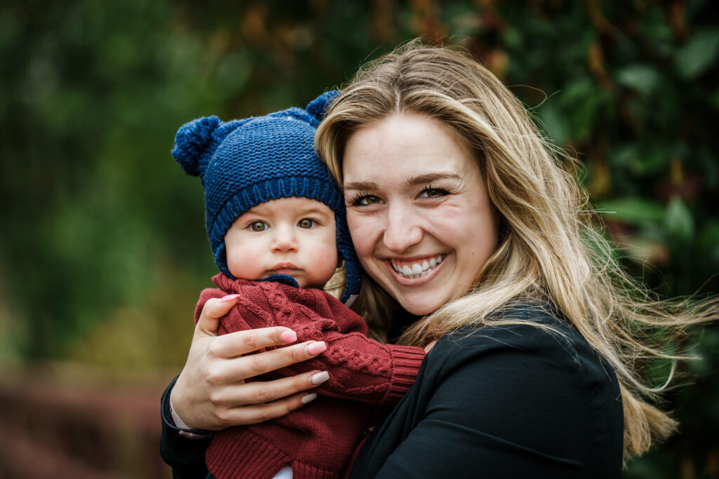 Aunt holding baby in blue knit hat at Knight Park in Collingswood NJ