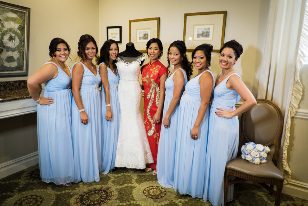 Bride in red Chinese qipao with bridesmaids in light blue dresses and wedding dress on display at Rockleigh Country Club