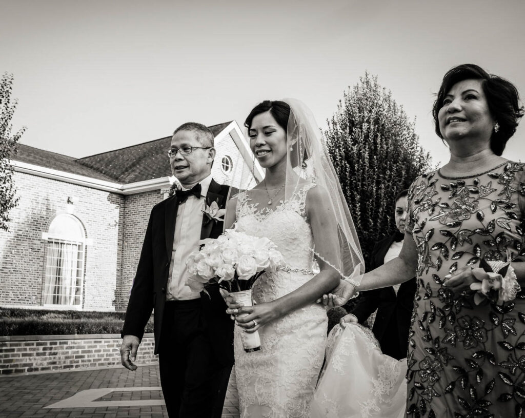 Bride in wedding gown on purple velvet sofa with crystal chandelier at Rockleigh Country Club