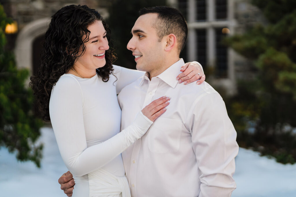 Engaged couple laughing together during a winter session at Skylands, Ringwood NJ