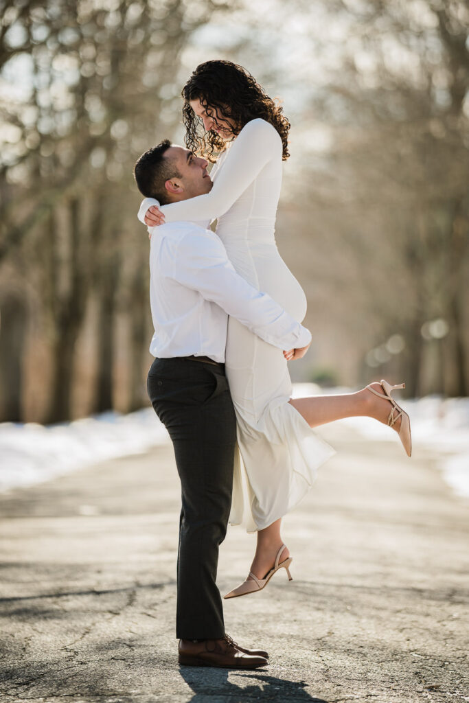 Couple embracing with snow on the ground at Skylands Botanical Garden, Ringwood NJ