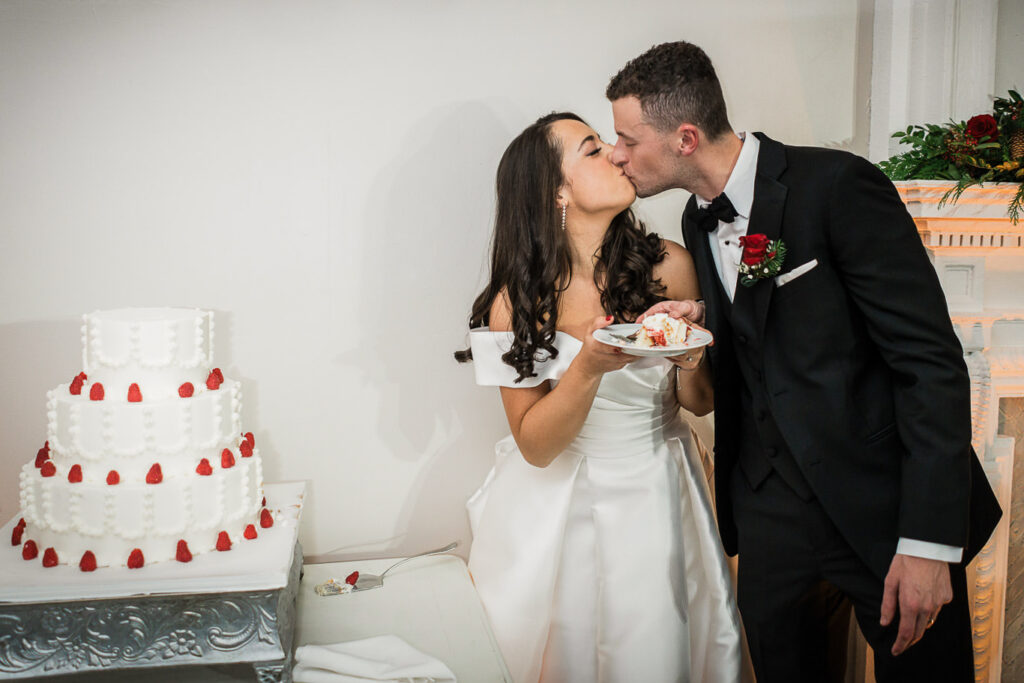 Newlyweds kissing during cake cutting at Skylands Manor
